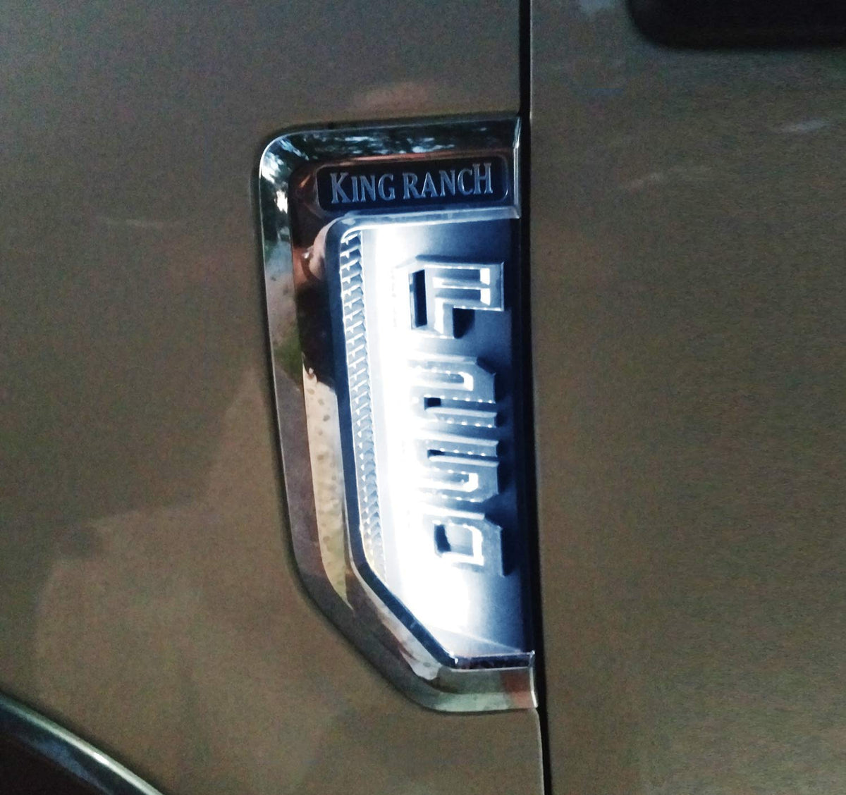 iJDMTOY lifestyle shot of Super Duty with illuminated emblems enhancing curb appeal