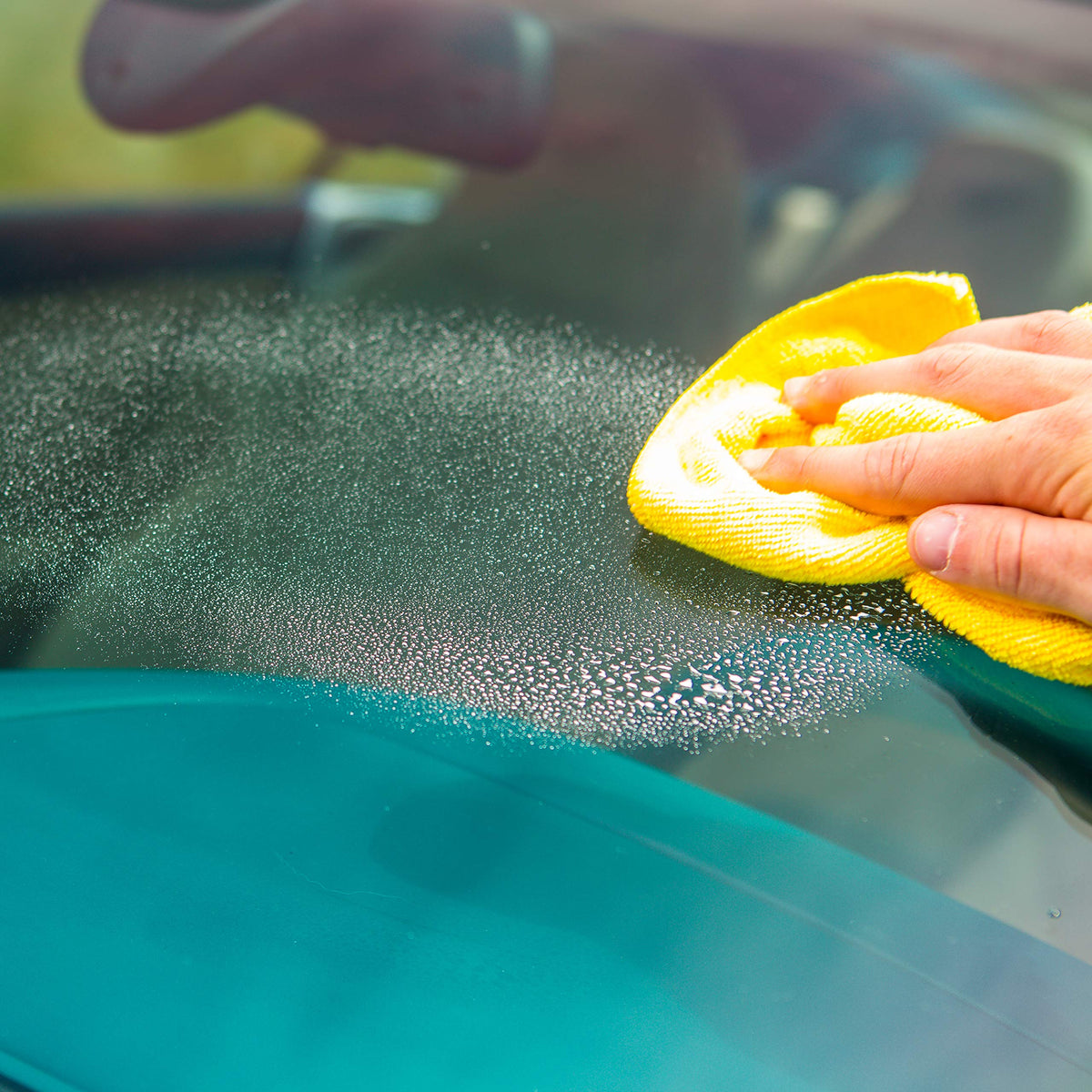 Invisible Glass spray in use on car window demonstrating streak-free cleaning