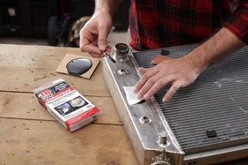 J-B Weld applied on a radiator tank demonstrating an in-place leak stop