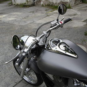 KEMIMOTO riser on a parked motorcycle in street setting showing comfort benefit