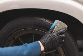 Side-by-side tire before and after KOCHCHEMIE glaze showing restored deep black