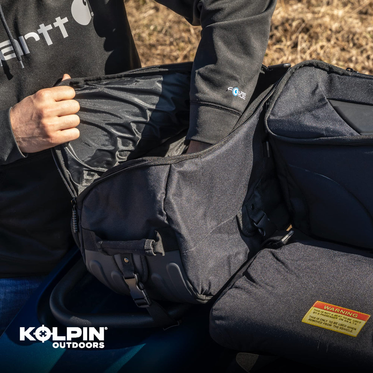 Kolpin Matrix Seat Bag next to helmet for size comparison showing compact capacity benefit