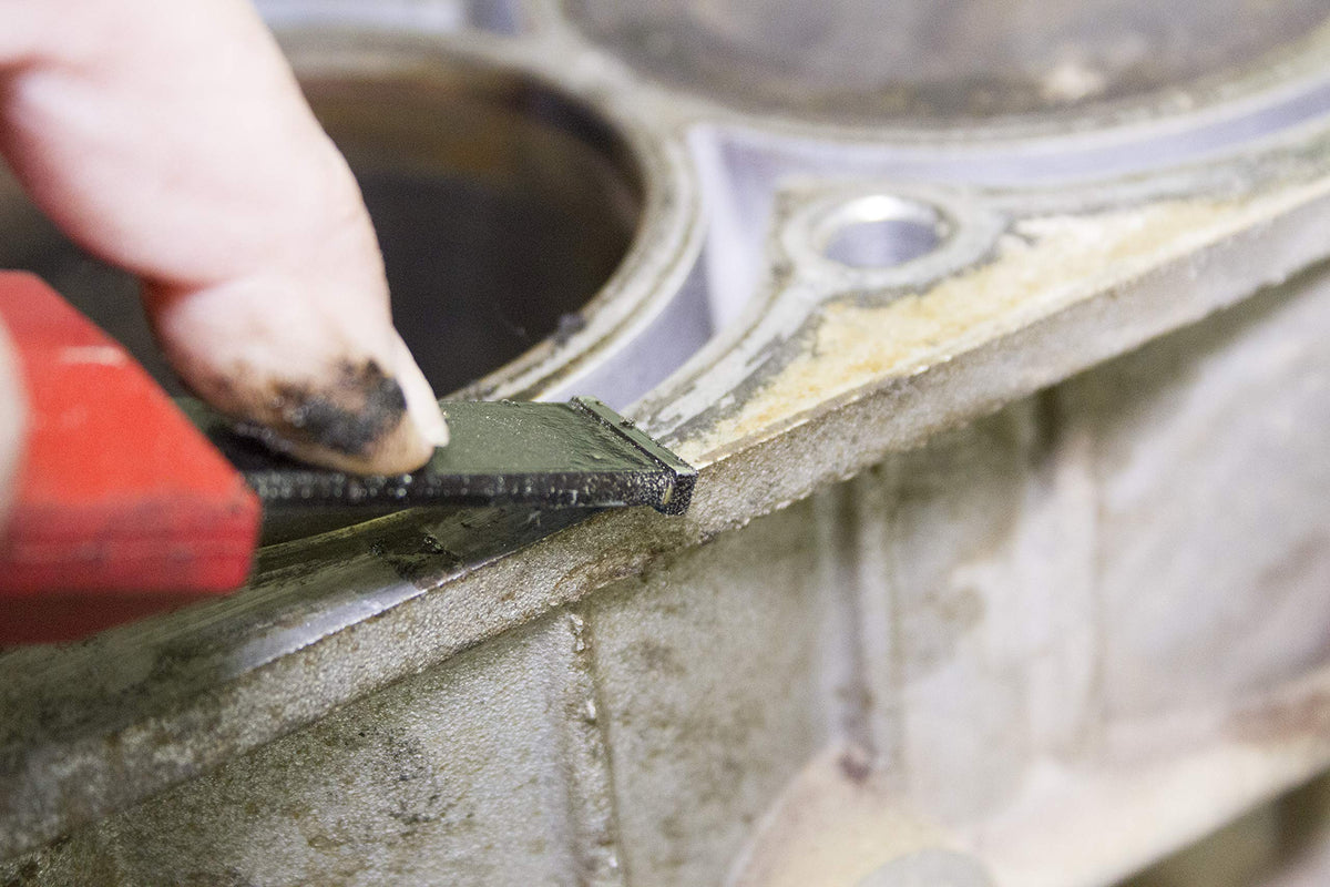 Lisle scraper in use removing gasket residue from an aluminum cylinder head for clean sealing