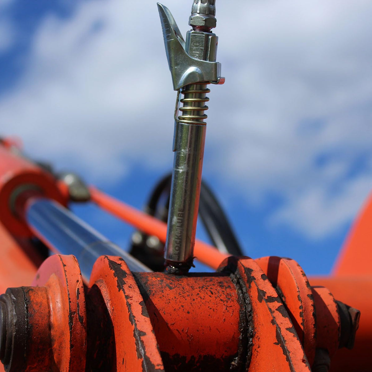 LockNLube in use on PTO shaft showing access to recessed zerk benefit