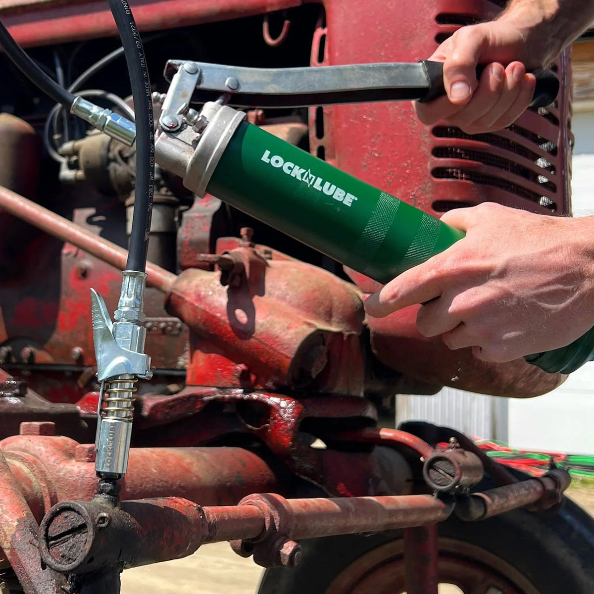 LockNLube next to ruler showing compact size and easy handling on jobs