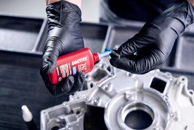 Loctite bottle in garage setting illustrating reliable fastener security during repairs