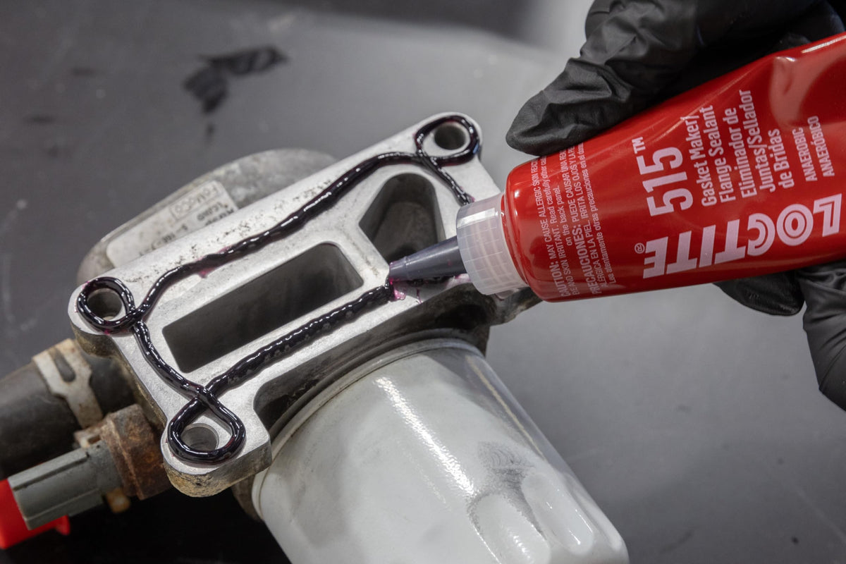 Loctite 515 being applied to thermostat housing demonstrating brand reliability and leak prevention