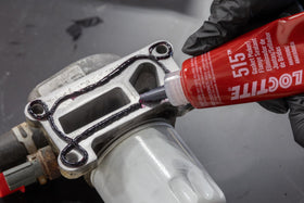 Loctite 515 being applied to thermostat housing demonstrating brand reliability and leak prevention
