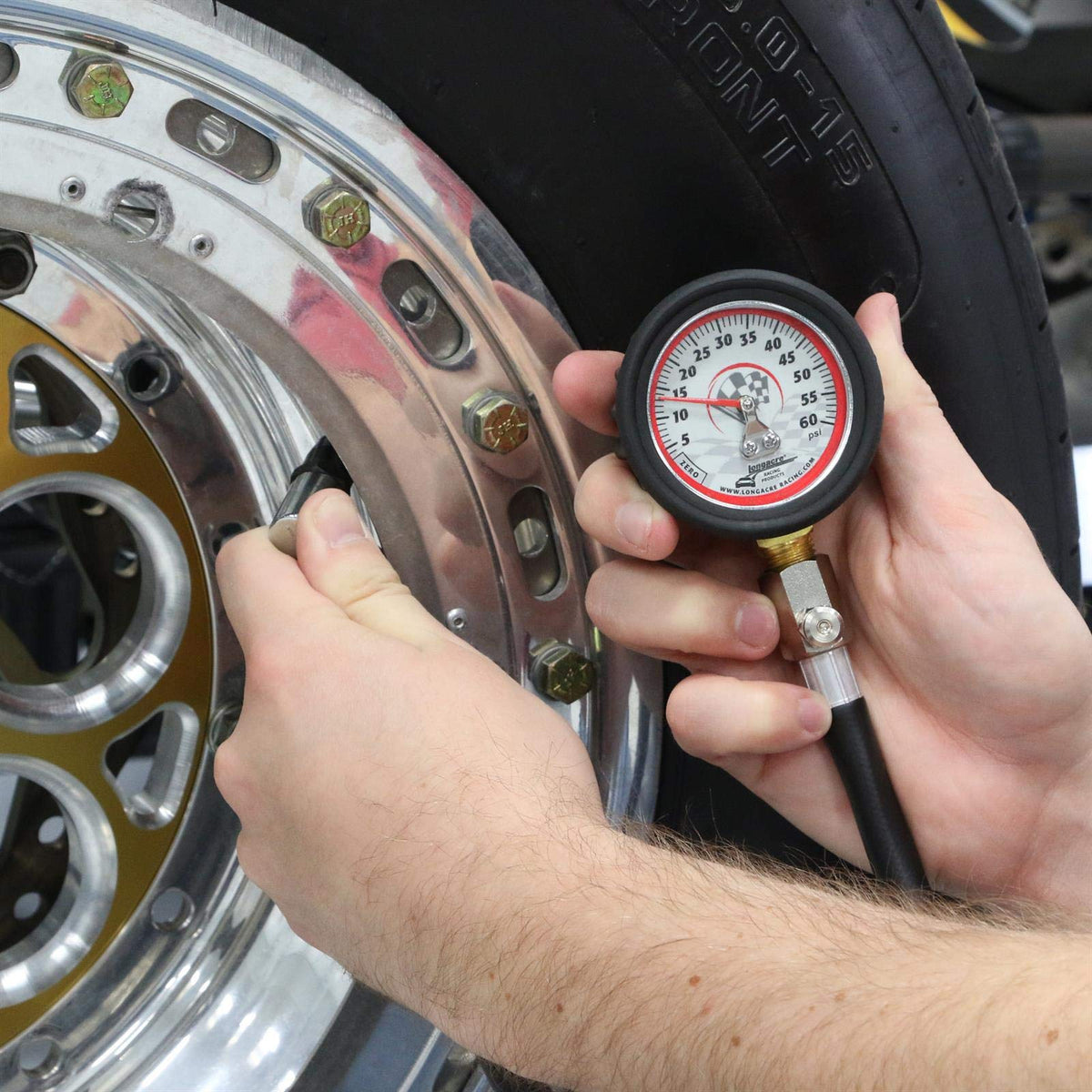Longacre gauge in use on car tire offering fast pressure verification