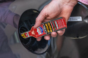 Lucas Oil octane booster held in hand for size comparison to show convenient 15 oz capacity
