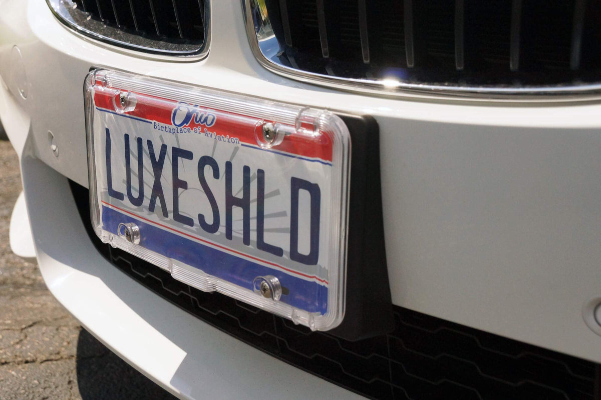Luxe Shield installed on sedan rear demonstrating protected plate visibility