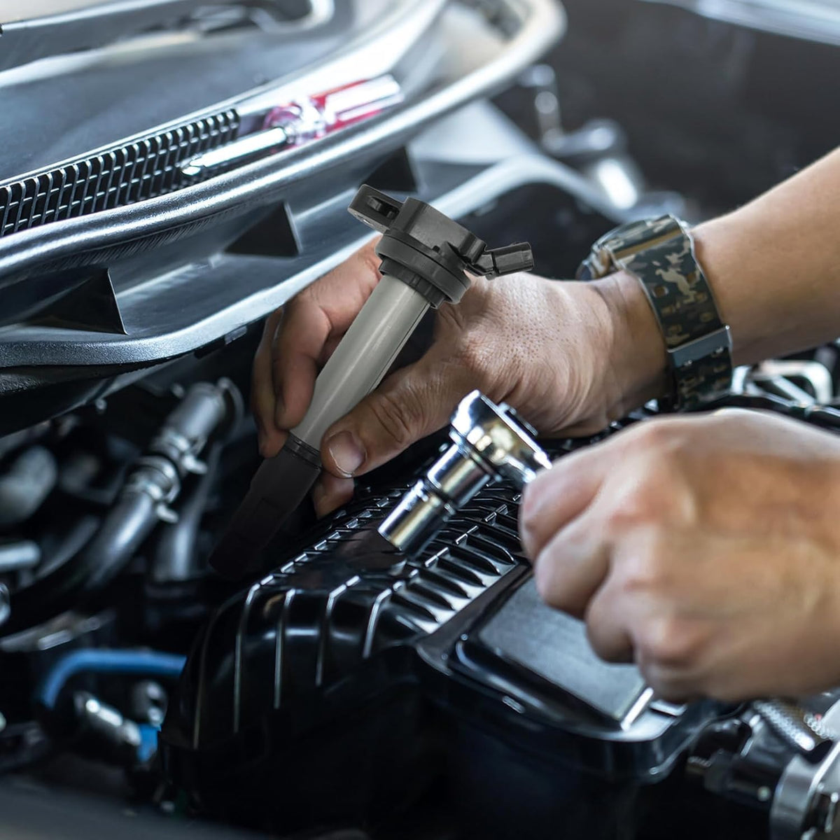 Mechanic installing Marsram coils and plugs in garage for faster starts