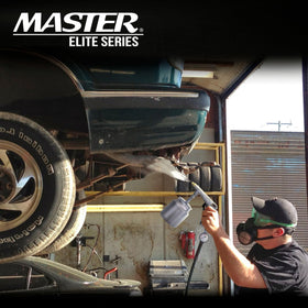 Master Airbrush gun applying bed liner in truck for durable protection