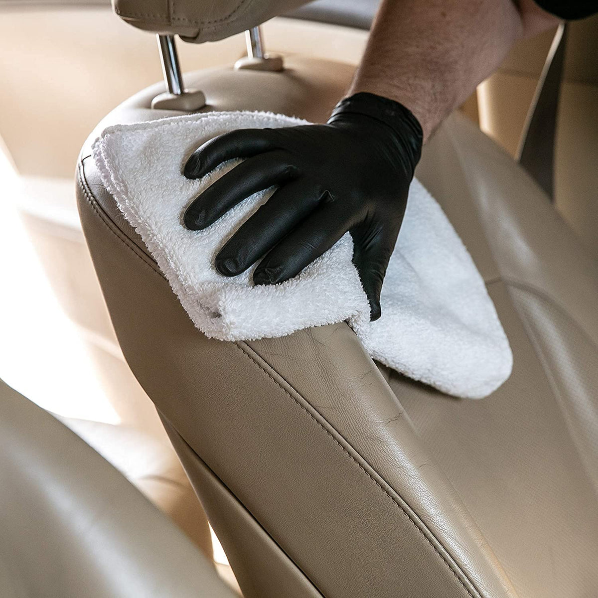 Meguiar's applying cleaner to car seat demonstrating deep-cleaning and conditioning benefit