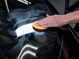 Meguiar's being applied to car door panel with a pad showing faster results