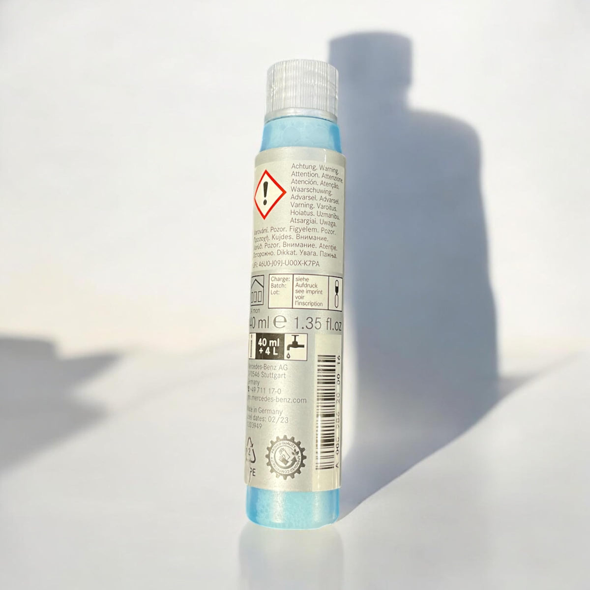 Mercedes‑Benz Summerfit concentrate being poured into a washer reservoir showing quick, measured mixing benefit
