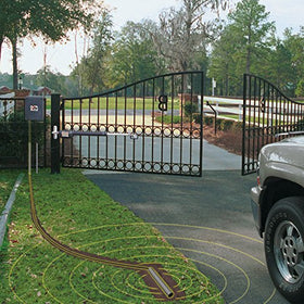 Mighty Mule FM140 installed beside driveway with car, enabling hands-free gate exit