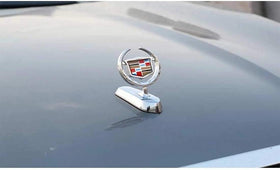 Mioteila Cadillac emblem mounted on Escalade in road setting enhancing presence