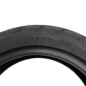 MMG rear 130/70-12 tire tread closeup highlighting block pattern grip
