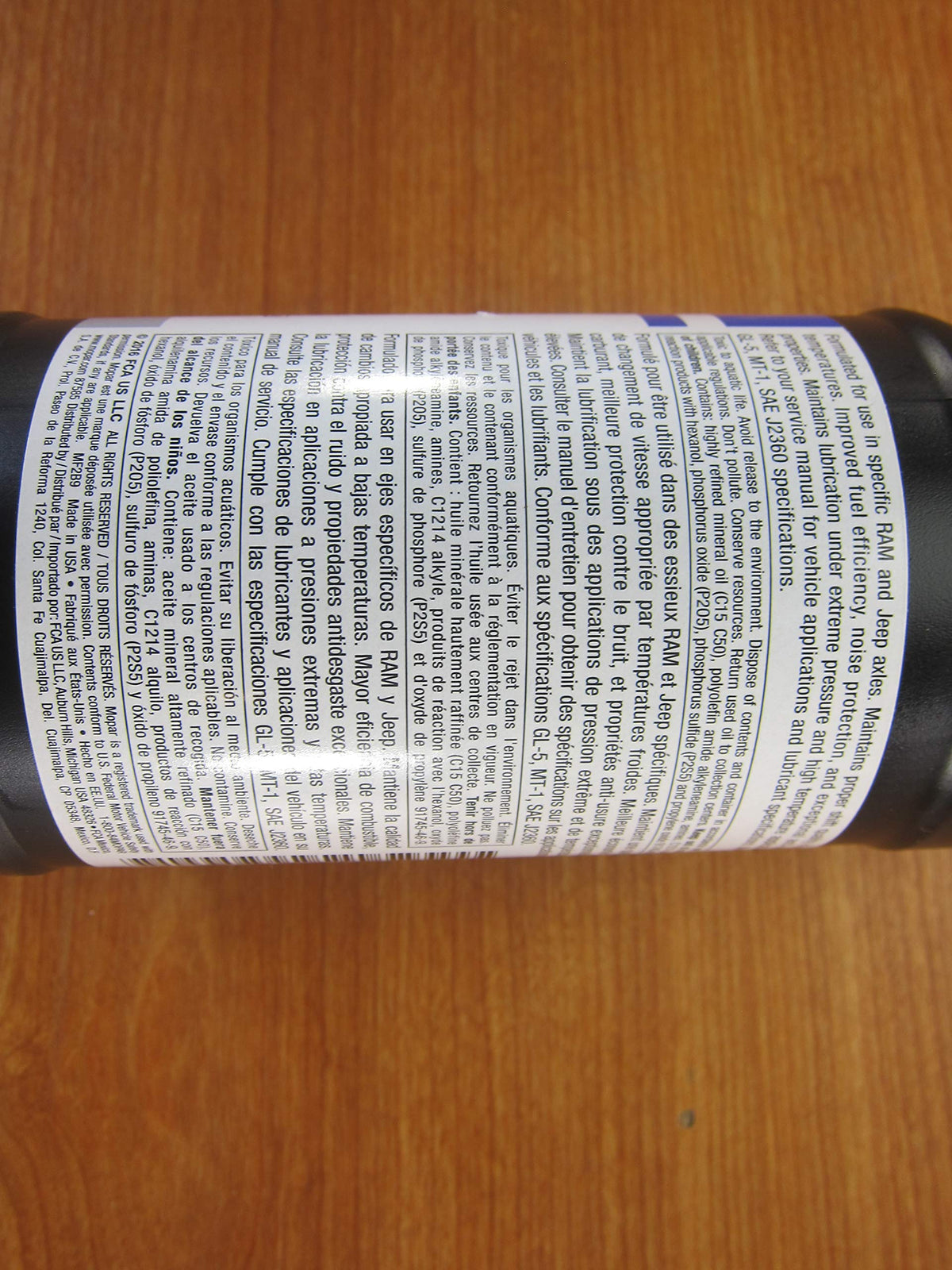 Mopar 2-quart bottle next to measuring tape showing compact size and correct service quantity