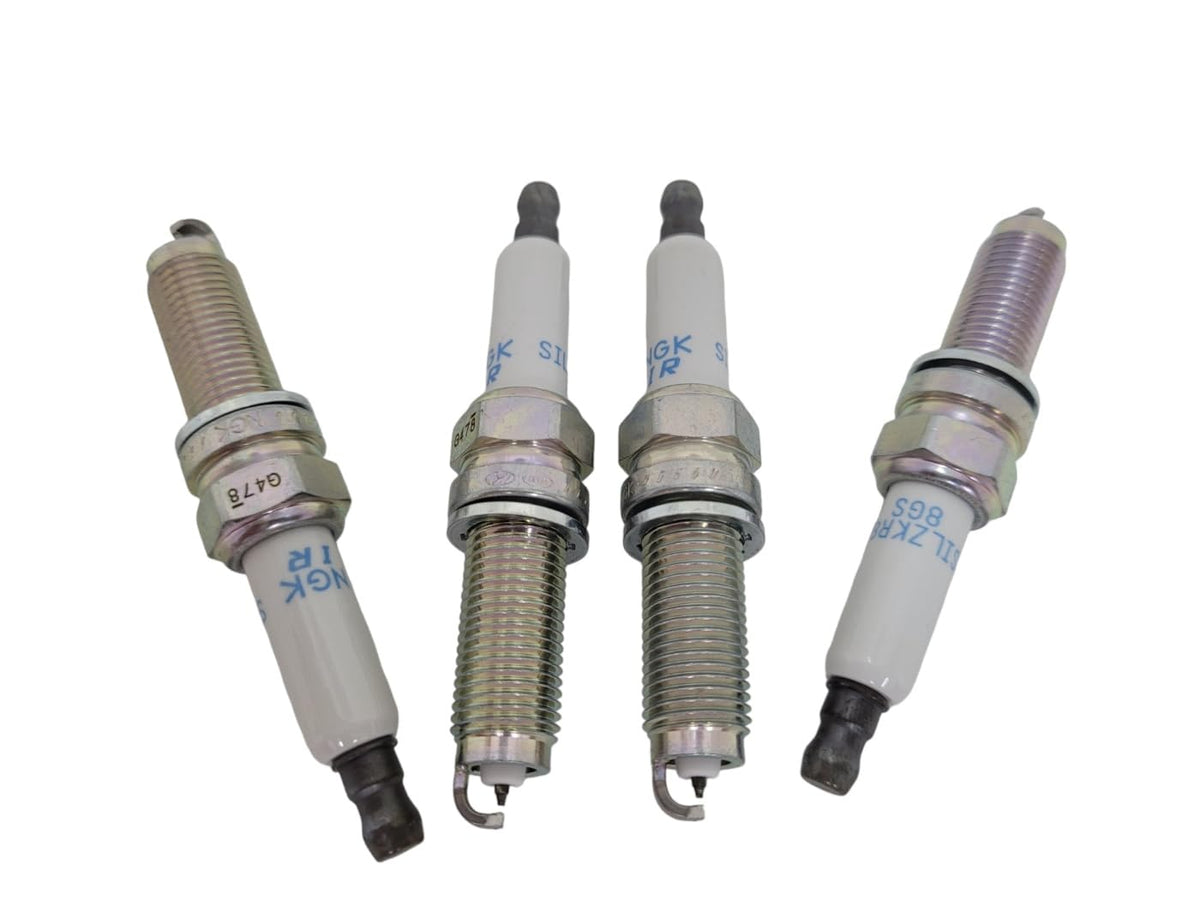 MOROTUS spark plug next to coin size comparison showing scale benefit