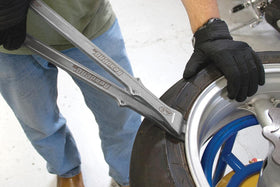 Motion Pro tool in use on a dirt bike tire demonstrating faster bead removal