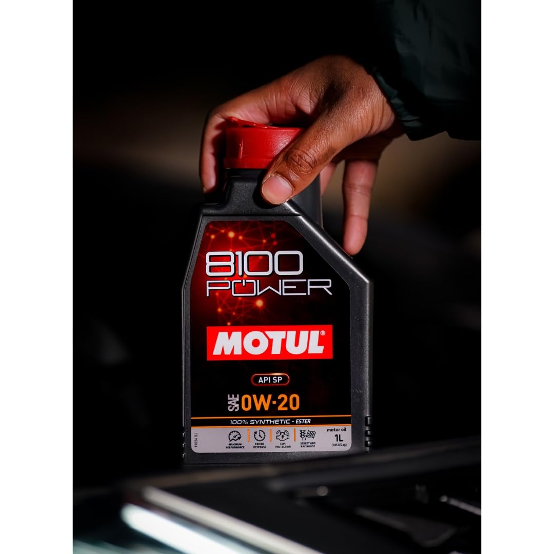 Motul 8100 Power bottle beside an engine bay for maintenance convenience
