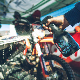 Motul MC Care E2 spray action on engine area demonstrating effective degreasing