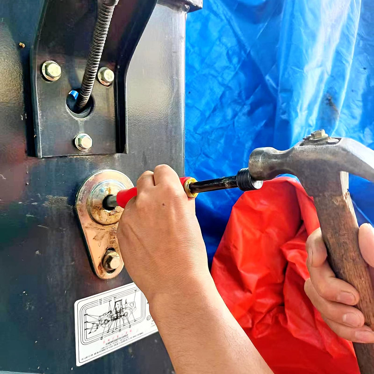Nagiee tool in use on a tractor zerk fitting clearing blockage to restore lubrication