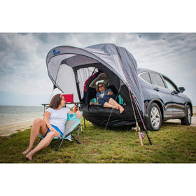Napier Sportz Cove next to a person and car showing size and fit for SUVs