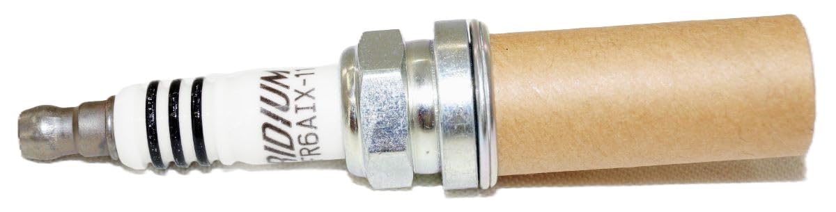 NGK 6619 beside a coin for scale showing compact plug size and easy handling during maintenance