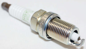 NGK spark plug being threaded into engine illustrating proper installation