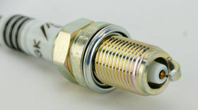 NGK spark plug next to ruler showing size and correct thread reach