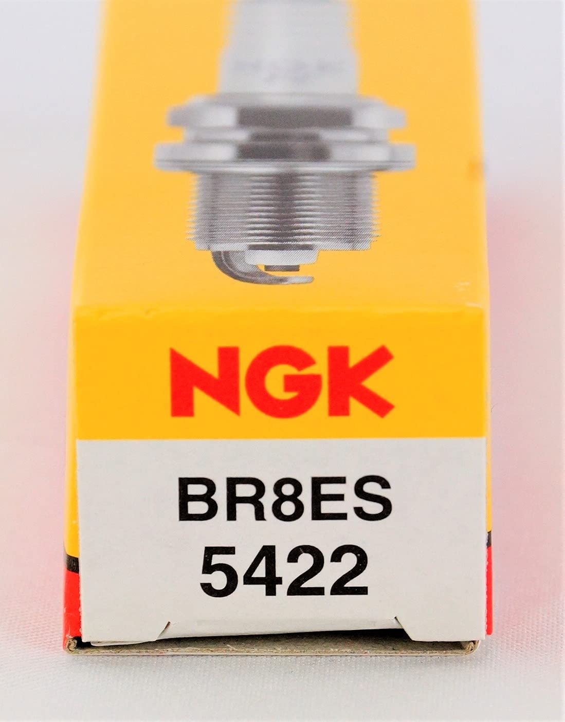 NGK BR8ES beside a coin for size comparison, helps confirm fitment benefit