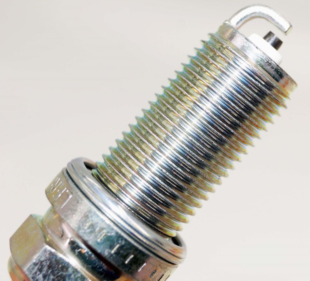 NGK spark plug gap measured to 0.9mm with gauge showing correct spark spacing