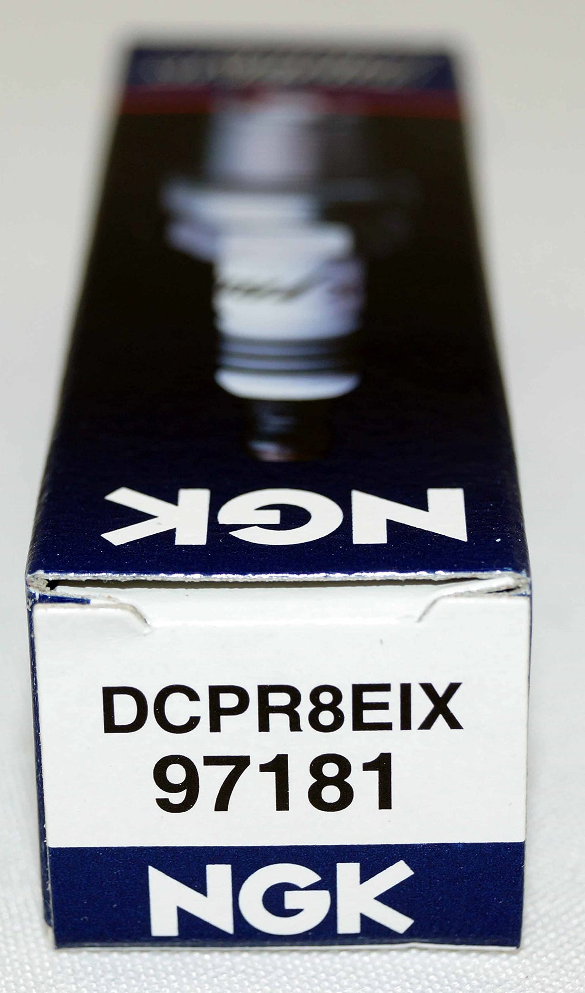 NGK iridium plug in garage lifestyle scene conveying dependable maintenance