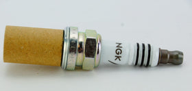 NGK spark plug in a garage setting portraying professional installation and performance benefit