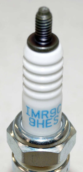 NGK plug next to ruler for size comparison to confirm fitment and installation ease