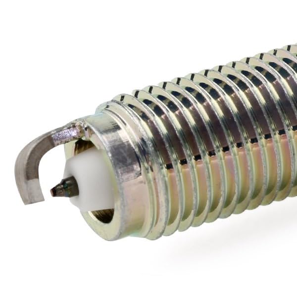NGK spark plug beside coin to show size and fitment clarity for buyers