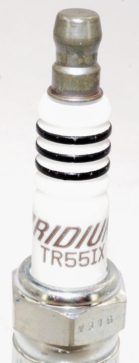 Six NGK TR55IX plugs arranged on table demonstrating complete 6-pack convenience