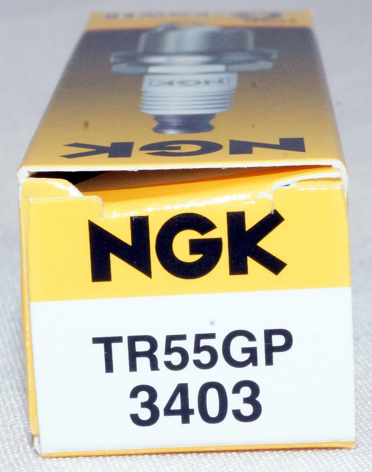 NGK plug in hand for scale demonstrating compact design and easy handling benefit
