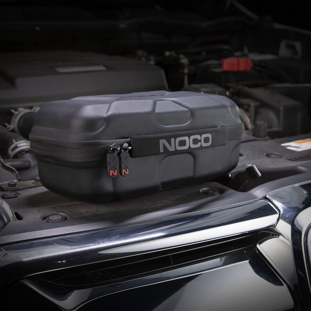 NOCO inside view with jump starter, clamps, and cables organized for travel