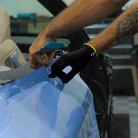 Off-Wrap glove in use with squeegee demonstrating smoother vinyl glide benefit