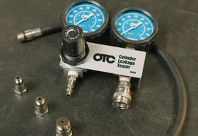 OTC 5609 connected to an engine spark plug hole demonstrating leak testing