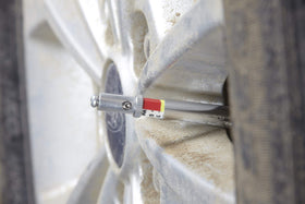 OTC 6596 in use on caliper demonstrating on-vehicle pad thickness check