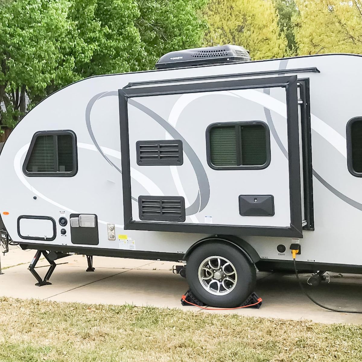 OULEME chocks under trailer in campsite scene illustrating secure parking
