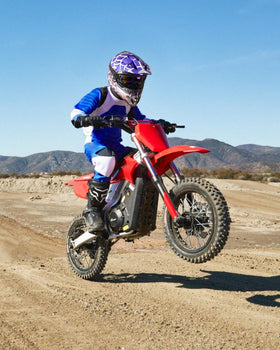 Child wearing Oumurs helmet riding ATV showing confident protection
