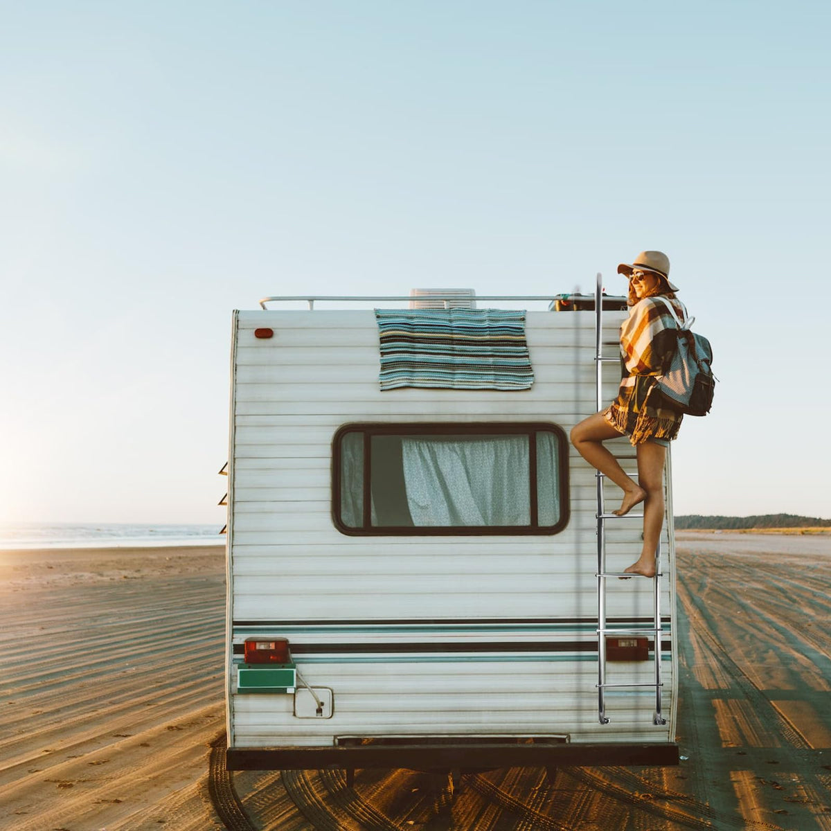 OUTPRIZE ladder on parked trailer lifestyle image conveying convenience