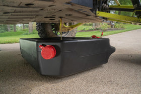 PAK pan positioned under a car in garage scene enabling clean professional fluid changes