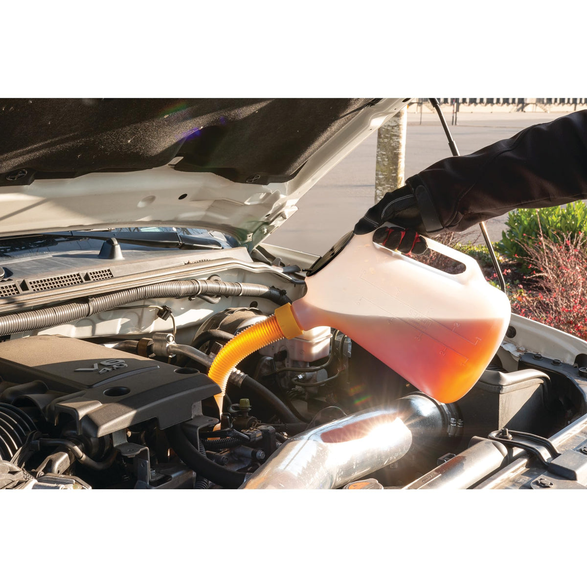 Performance Tool W4046 being poured into engine oil fill for controlled transfer